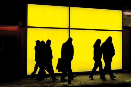 People walking in front of a yellow window