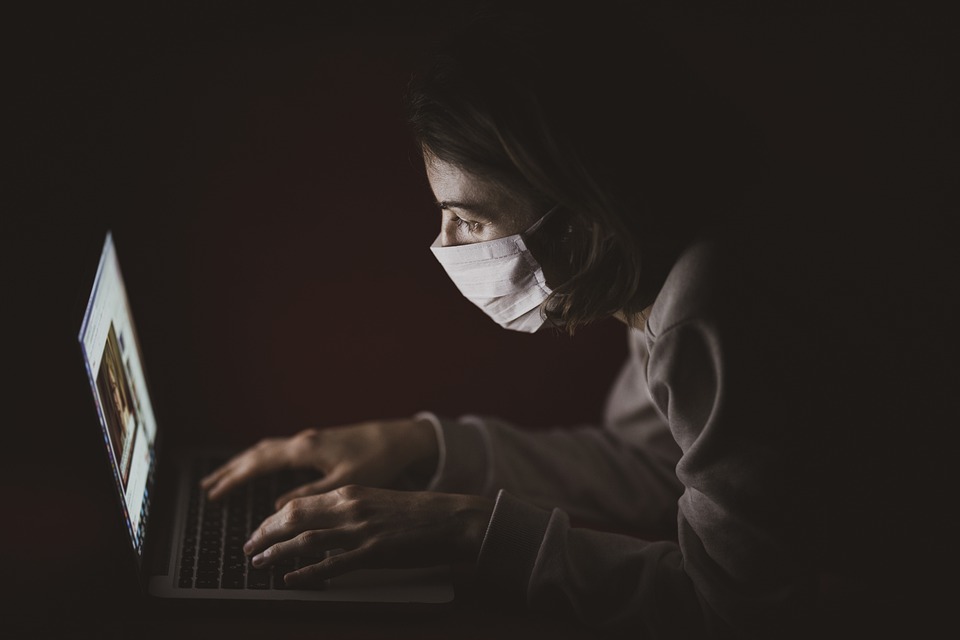 Masked person at laptop