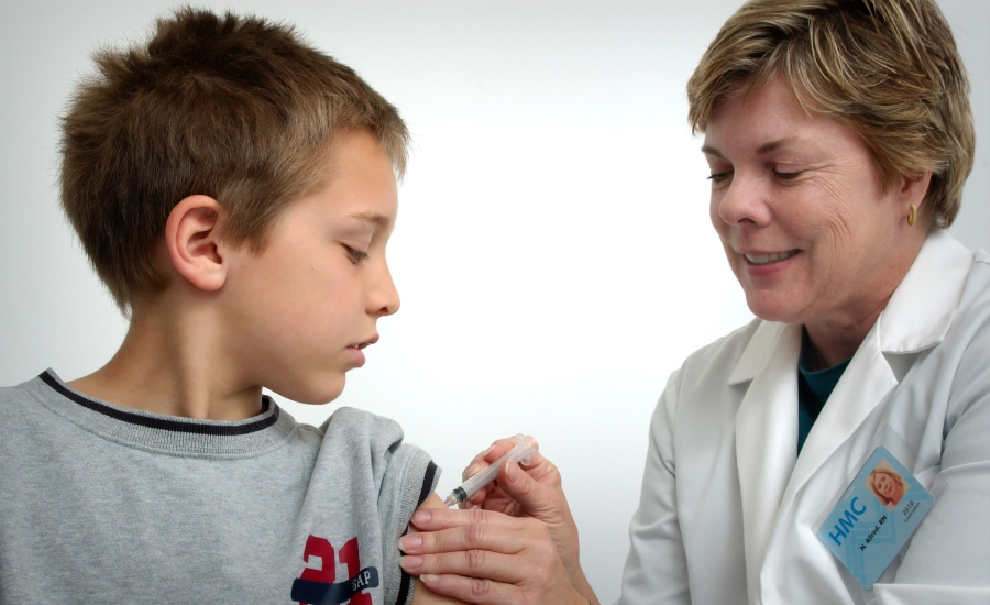 Nurse wearing badge gives child vaccine