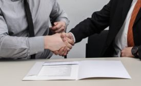 Two businessmen shake hands over contract