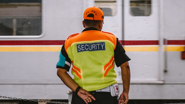 Security guard stands in front of train