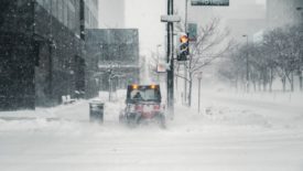 Emergency worker clears snowy road