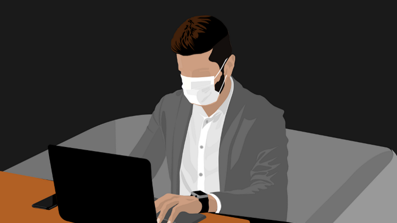 man wearing mask works at laptop