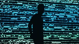 man standing by video analytics wall