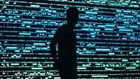 man standing by video analytics wall