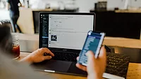 Employee working on desktop and cell Employee working on desktop and cell