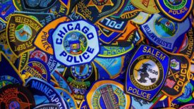 police badges of several cities stacked together
