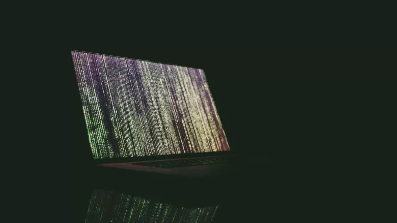 open laptop with code in dark room