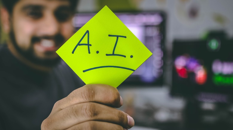 man holding sticky note that says AI