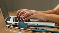 hands on laptop with stethoscope hands on laptop with stethoscope