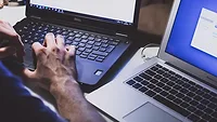 someone working at two laptops someone working at two laptops