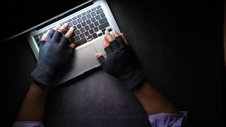 gloved hands on laptop keyboard