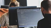 two people working at desktops two people working at desktops