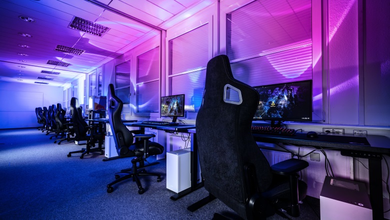 row of gaming chairs at long desk