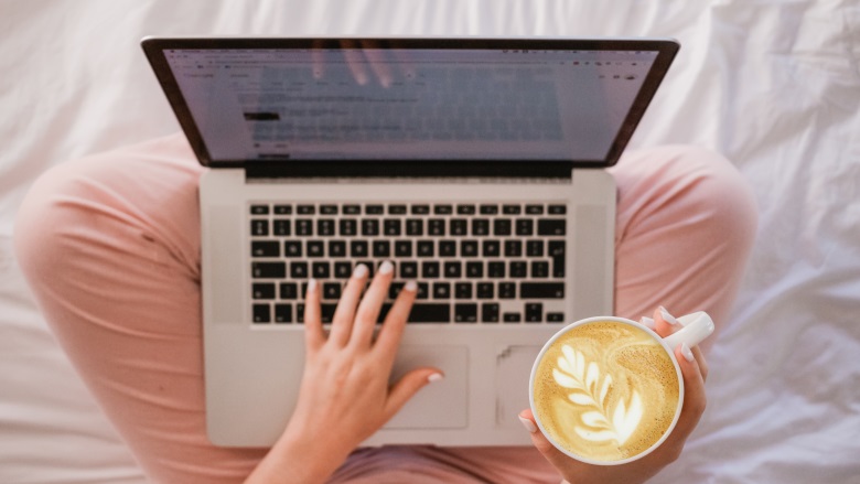 person using laptop with latte