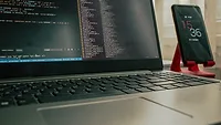 computer next to phone on red stand computer next to phone on red stand