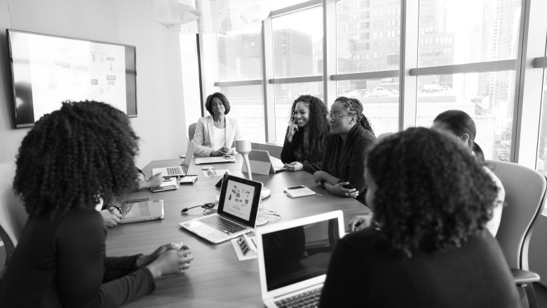 black and white photo of women at conference table