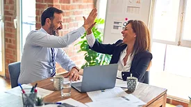 people at work desk high fiving