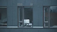 person working on computer near a window person working on computer near a window