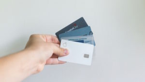 Person holding several credit cards
