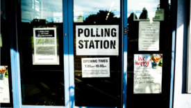 Polling station sign in glass door