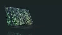 Laptop with dark screen and green symbols