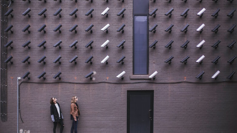 Video cameras on wall with people looking at them