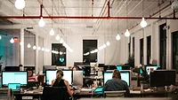 People working together at long desks People working together at long desks