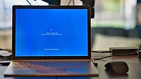 Laptop with blue screen and spinning icon Laptop with blue screen and spinning icon