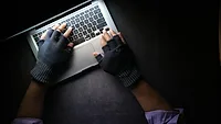Hands wearing fingerless gloves and using laptop Hands wearing fingerless gloves and using laptop