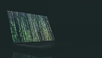 Open laptop in dark room with green text on screen Open laptop in dark room with green text on screen