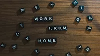 Black letter beads that spell out 'work from home' on wooden table Black letter beads that spell out 'work from home' on wooden table
