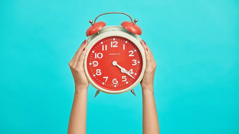Woman holding alarm clock