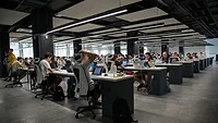 People working together in gray shared office space People working together in gray shared office space