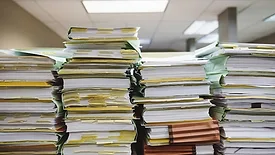 Stacks of papers and folders on a desk