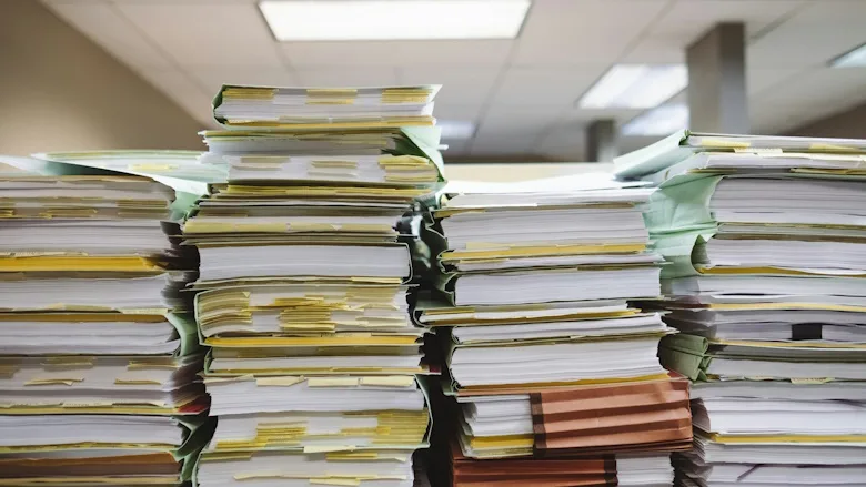 Stacks of papers and folders on a desk
