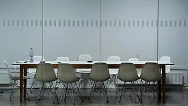 White conference table surrounded with plastic chairs