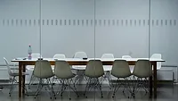 White conference table surrounded with plastic chairs White conference table surrounded with plastic chairs
