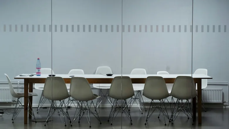 White conference table surrounded with plastic chairs