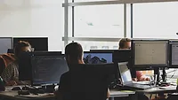 People working together at shared desk People working together at shared desk