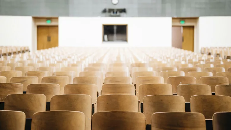 Rows of wooden seats in an auditorium