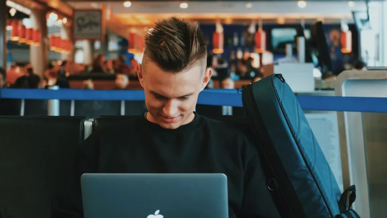 Man on laptop at airport 