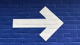 White arrow on blue wall 