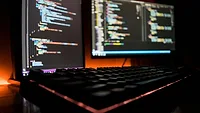 Two monitors opened up to coding software