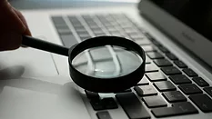 Magnifying glass over laptop