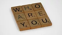 "Who are you" spelled in scrabble tiles