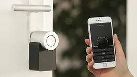 Person holding phone to smart lock