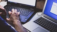 Person working on two laptops at the same time