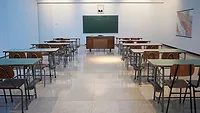 Classroom with rows of desks facing a chalkboard