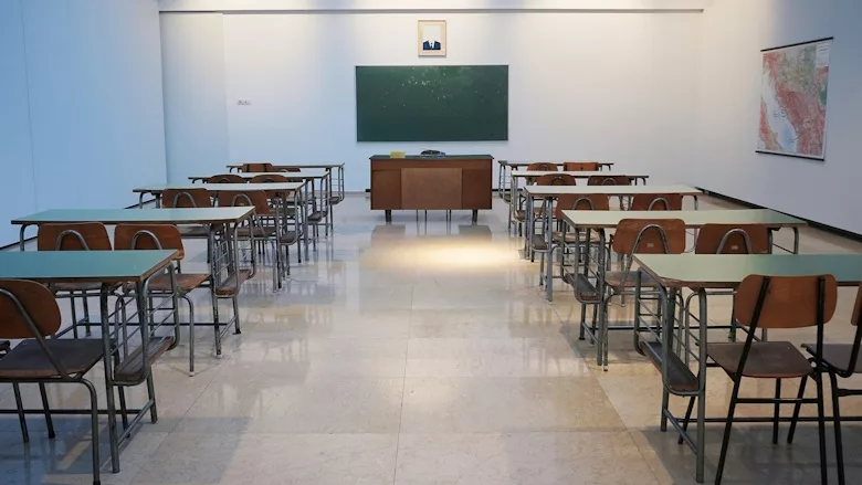 Classroom with rows of desks facing a chalkboard